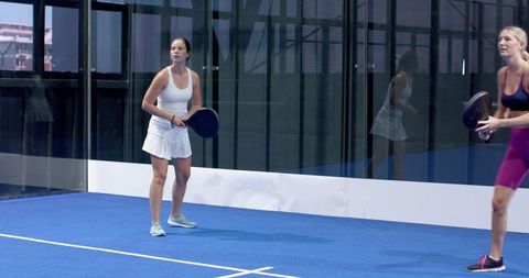 Female Padel Players Ready for Action on Indoor Court