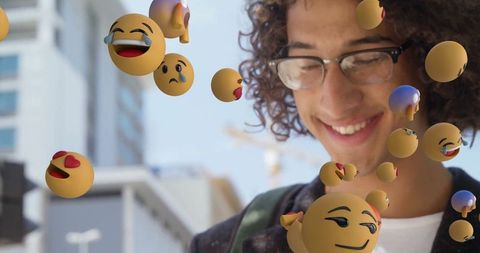 Young man interacting with 3d emojis outdoor