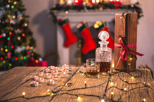 Bottle of whiskey with glass and christmas decoration on wooden table