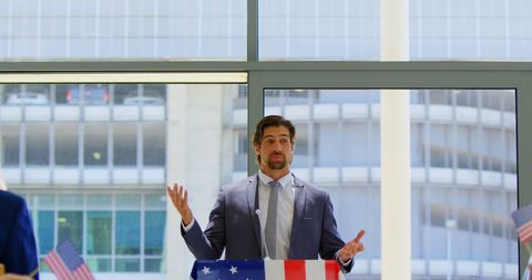 Confident speaker addressing audience with american flags