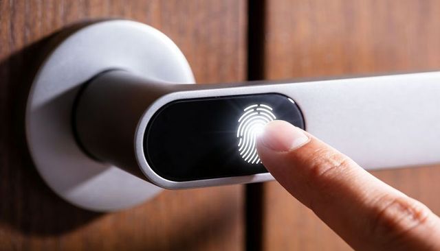 Smart fingerprint door handle unlocking with illuminated biometric sensor on wood door lever