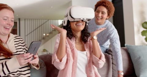 Friends enjoying virtual reality experience together at home