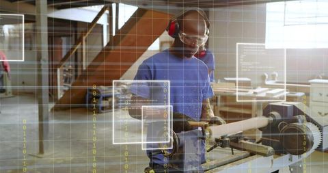 Woodworker turning lathe spindle in workshop wearing safety glasses and ear protection