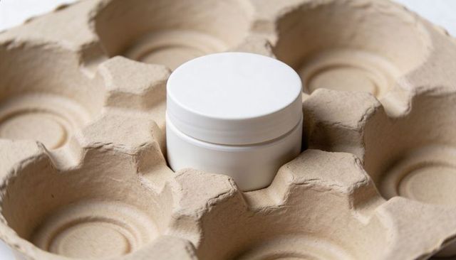 White Cosmetic Jar Nestled in Molded Pulp Tray Minimalist Eco Packaging Closeup