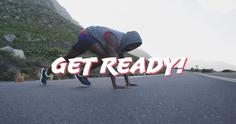 Athlete in Start Position on Scenic Mountain Road Inspires Motivation