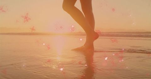 Woman gently wading through water at sunset with serene atmosphere