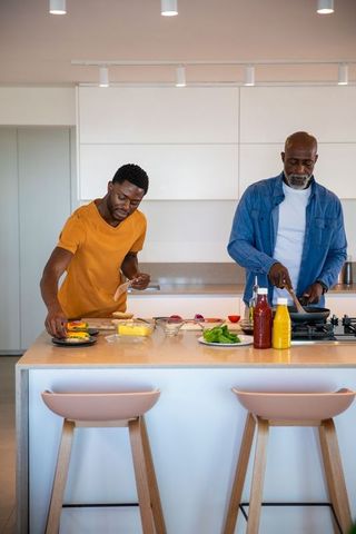 Father and Son Joyfully Cooking Together in Modern Kitchen