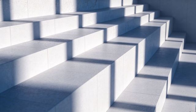 Minimalist Concrete Tiered Seating with Window Shadows for Modern Interior Design
