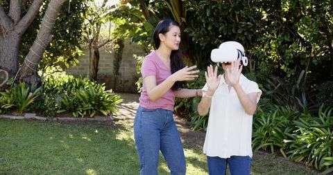 Mother and Daughter Enjoy Virtual Reality in Lush Garden