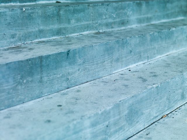 Close-up view of concrete steps exhibiting a minimalistic design. Perfect for use in architectural presentations, construction marketing materials, urban planning documents, and modern interior or exterior design showcases.
