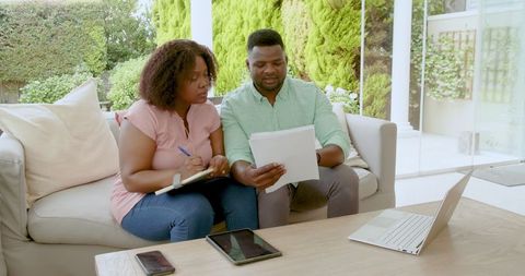 Mature couple managing household finances with digital devices