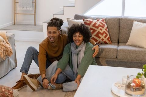 African american couple sitting on living room floor embracing cozy home moments