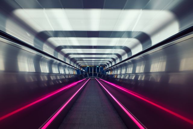 Depicting illuminated tunnel with neon lights creating sense of speed and movement. Useful for projects related to technology advancements, futuristic design, urban transportation, and modern travel environments. Excellent for background images or any content focusing on innovation and metro areas.