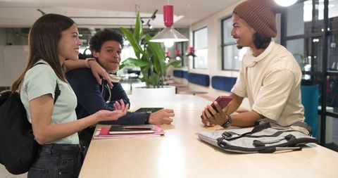 Young african american students collaborating in modern coworking space sharing notebooks