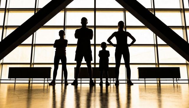 Standing silhouetted family in backlit glass atrium, symmetry and subtle reflection
