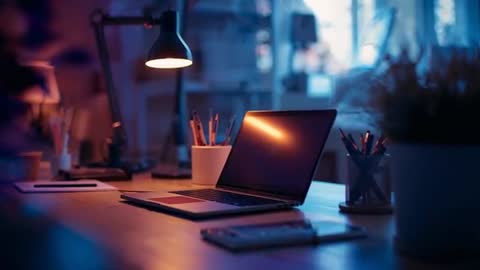 Cozy Home Workspace with Illuminated Laptop and Lamp Light