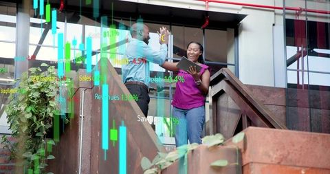 High-fiving professionals celebrating data win with tablet and augmented analytics on terrace