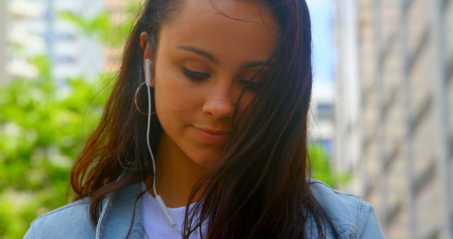 Young Woman Listening to Music on Earphones in Urban Environment - Download Free Stock Images Pikwizard.com