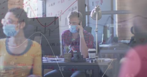 Office team working amidst covid-19 pandemic with data overlay