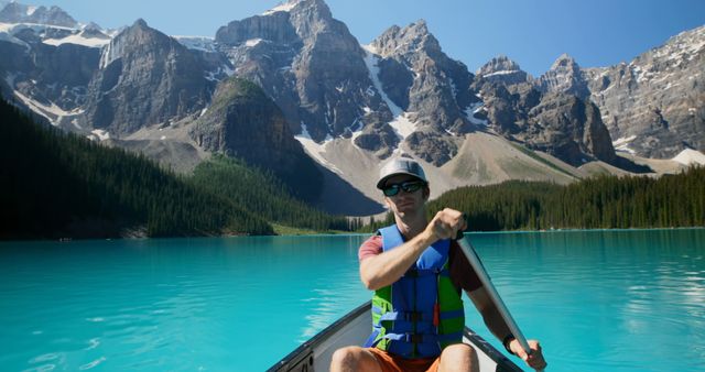 Adventurous Man Canoeing on Turquoise Lake with Majestic Mountain Background - Download Free Stock Images Pikwizard.com