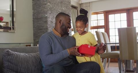 African American Father Receiving Gift From Daughter at Home
