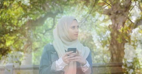Hijabi Woman Using Smartphone in Serene Park