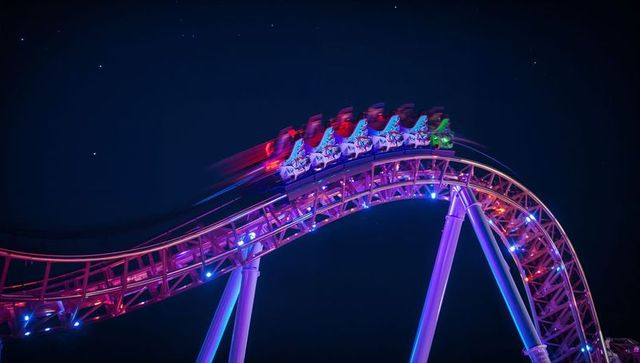 Thrilling Neon-Lit Roller Coaster at Night