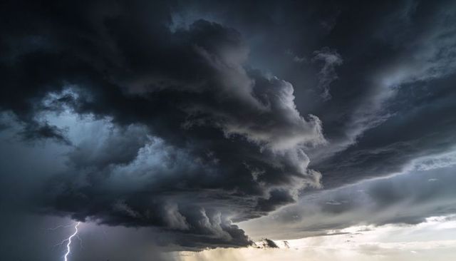 Dramatic Shelf Cloud Rolling Over Low Horizon Plains with Jagged Lightning and Sunlit Rain