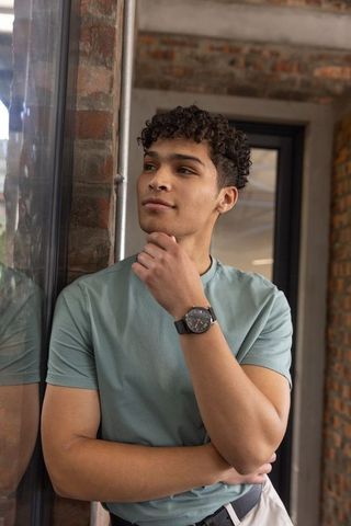 Confident man in modern coworking space checking time