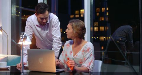 Working Late: Business Partners Collaborating on Project at Night