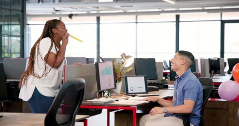 Smiling colleagues discussing project in modern office