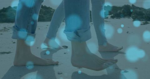 Couple Walking Barefoot on Beach with Light Effects
