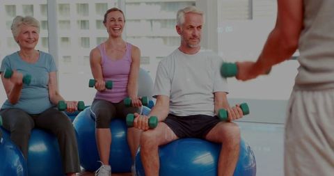 Seniors Enjoying Fitness Class with Weights on Stability Balls