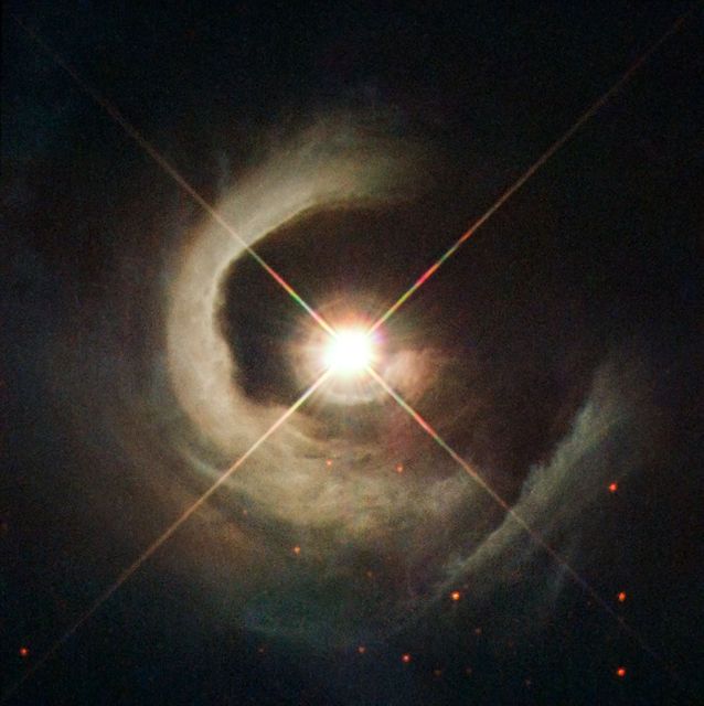 Helical reflection nebula spiraling from V1331 Cyg captured by Hubble Space Telescope. Young T Tauri star contracting to become a main sequence star. Unique view along the star's pole revealing the star and surroundings free of circumstellar dust. Ideal for educational content, space exploration articles, astronomy studies, and scientific presentations on young stellar objects.