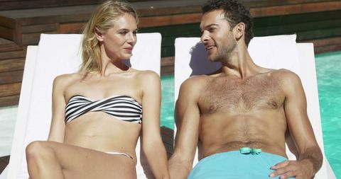 Attractive Couple Sunbathing by Poolside in Relaxing Environment