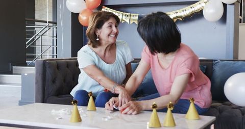 Senior Friends Preparing Birthday Celebration with Smiles and Balloons