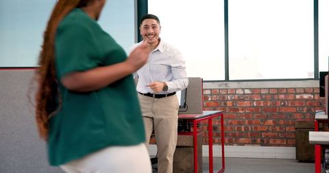 Colleagues dancing joyfully in office celebrating successful business