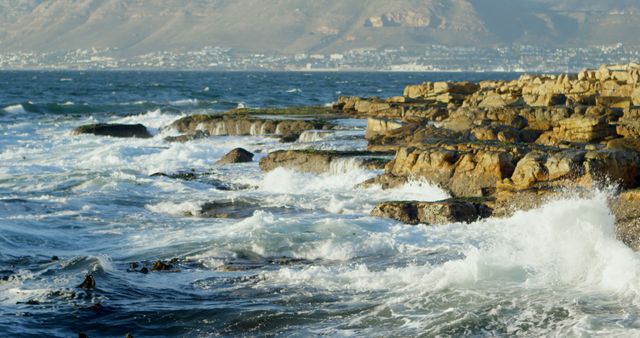 Waves crash against rocky shores, showcasing nature's power. The dynamic ocean scene emphasizes the beauty and force of the natural world.