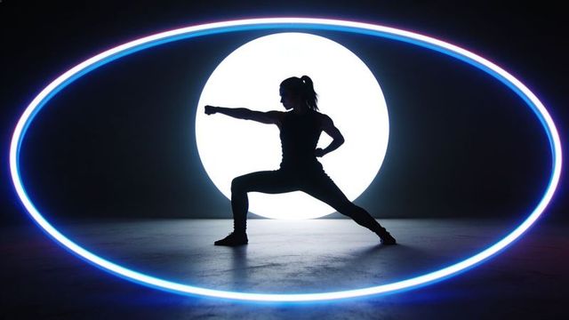Female athlete performing martial arts silhouette framed by neon oval and led disk