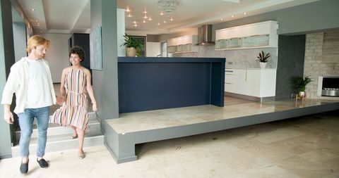 Happy Couple Enjoying New Home Interior Next to Kitchen