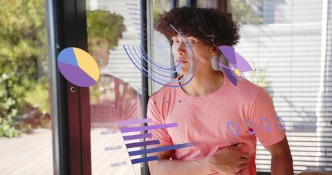 Young man in coral t-shirt clutching chest by window with ar health data overlays