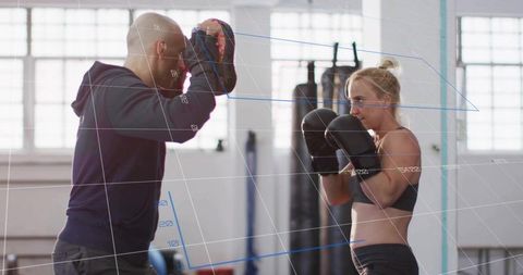 Female Boxer Training with Coach in Gym with Focus Mitts