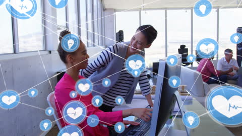Two Women Collaborating in Digital Office Environment