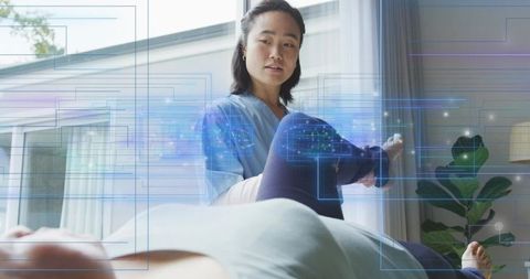 Caregiver supporting leg during home physical therapy with augmented reality overlays