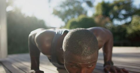 Athletic Man Doing Outdoor Push-Ups in Sunlight