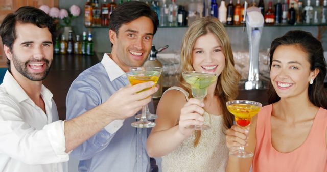 Group of friends enjoying a night out by toasting with cocktails at a bar. Perfect for use in advertising nightlife experiences, social events, and fun gatherings with friends. Ideal for illustrating youth, joy, and camaraderie in promotional materials and social media campaigns.
