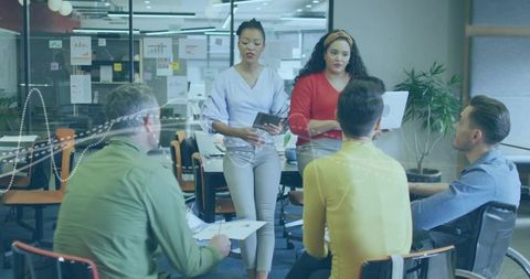 Diverse team presenting and collaborating around meeting table with wheelchair inclusion