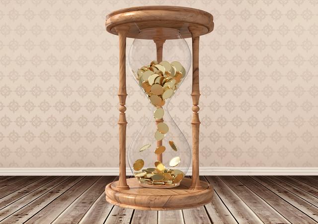 Digital composite image of hourglass with gold coins inside