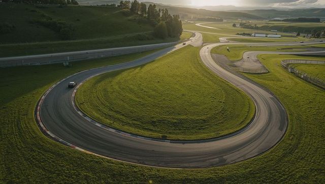Racing car conquers challenging race track hairpin on scenic day