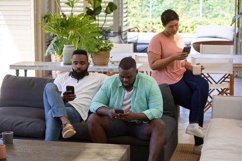 Multiracial Group Relaxing on Patio Engaging with Smartphones